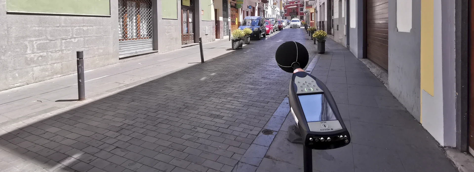 Sonómetro midiendo el nivel de ruido en una calle pavimentada con Zoruflex