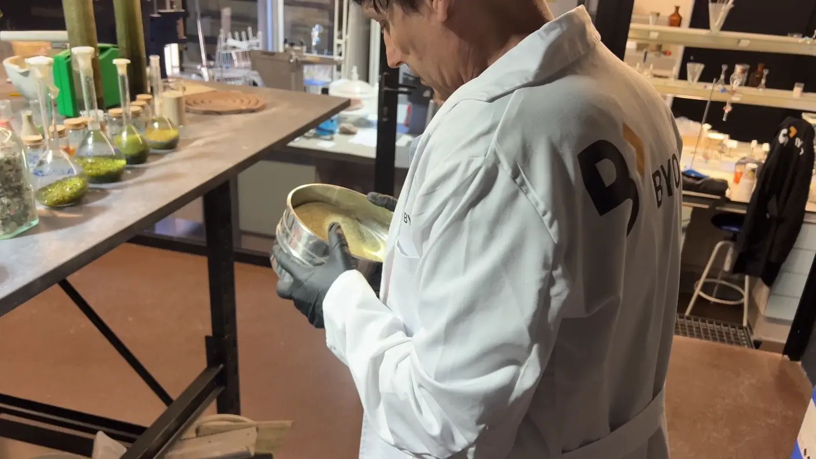 Técnico tamizando árido de vidrio reciclado en el laboratorio