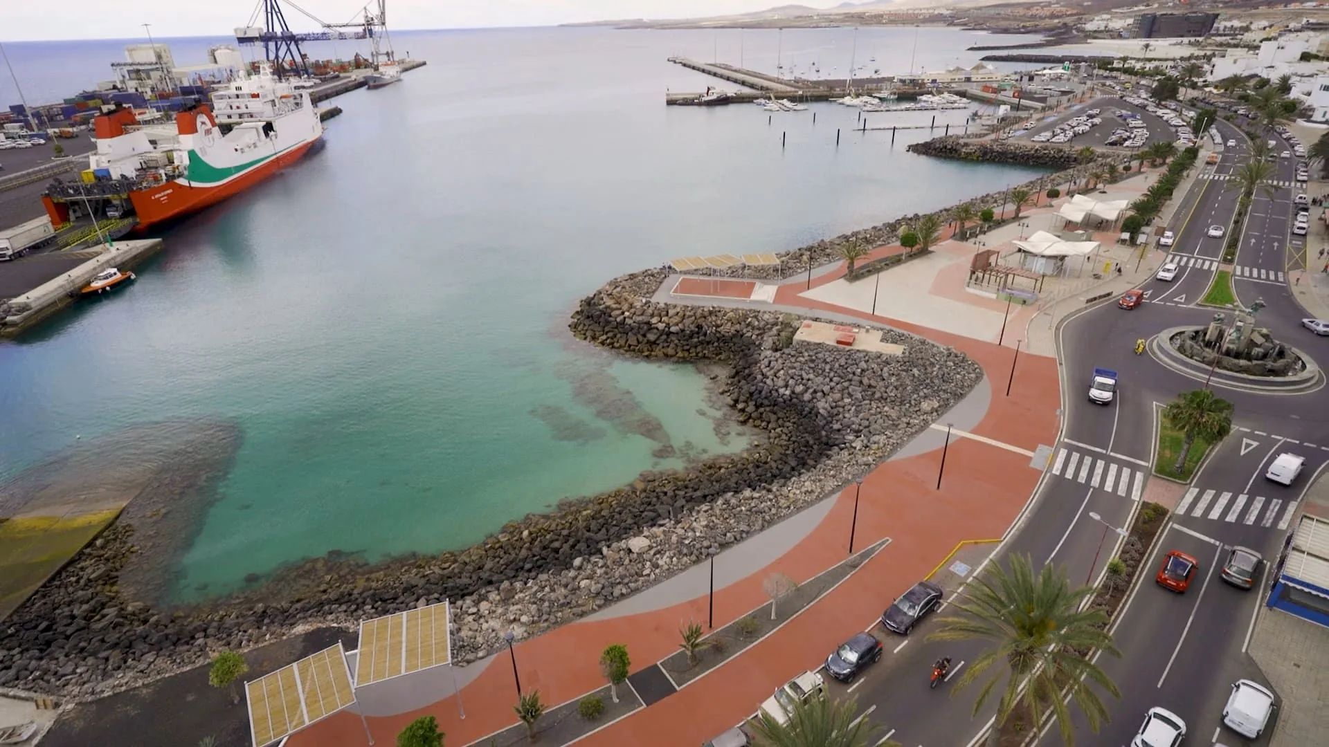 Vista aérea del paseo marítimo de Puerto del Rosario con pavimento rojo junto al puerto